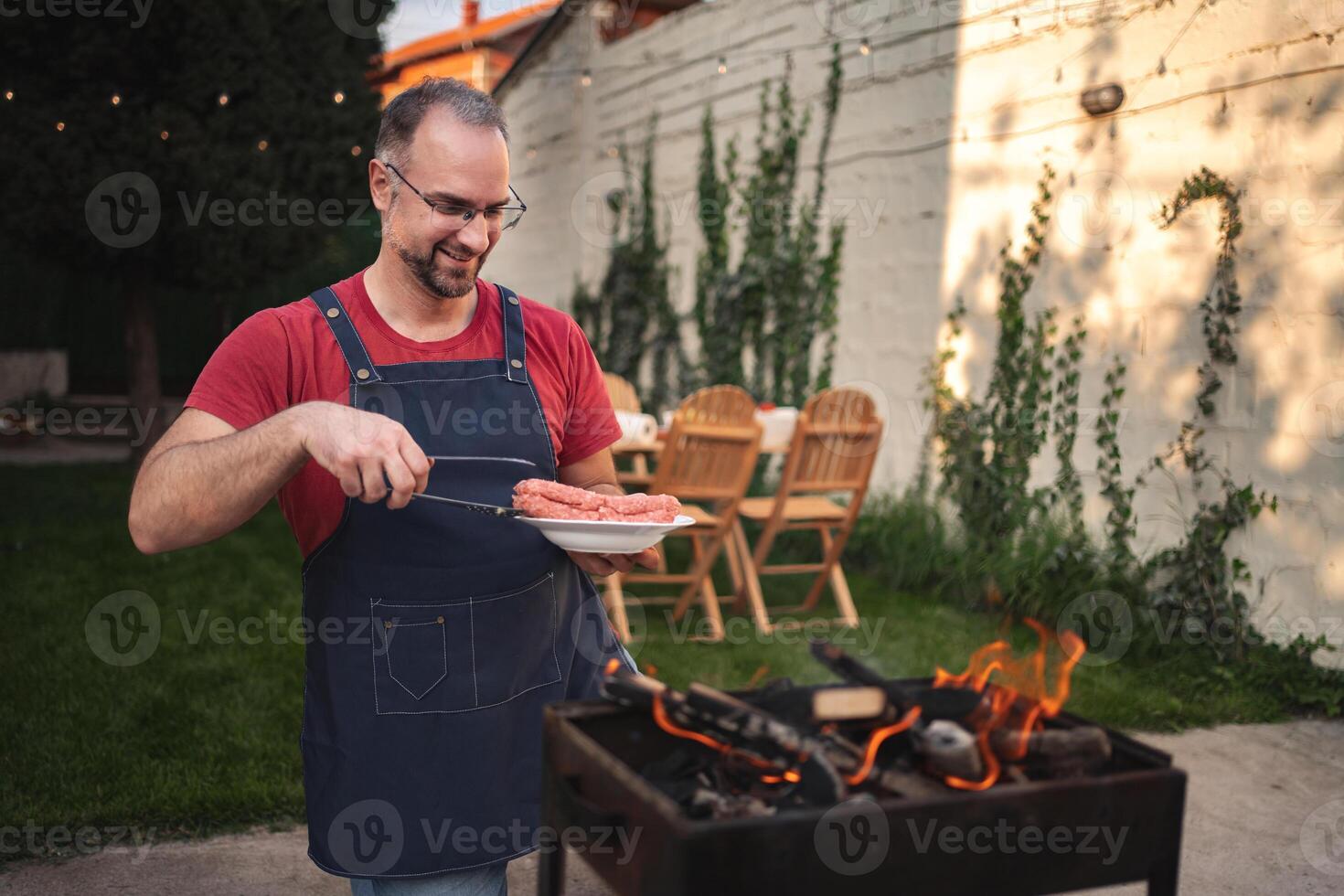 Grilling delicious sausages in a cozy backyard gathering at sunset photo