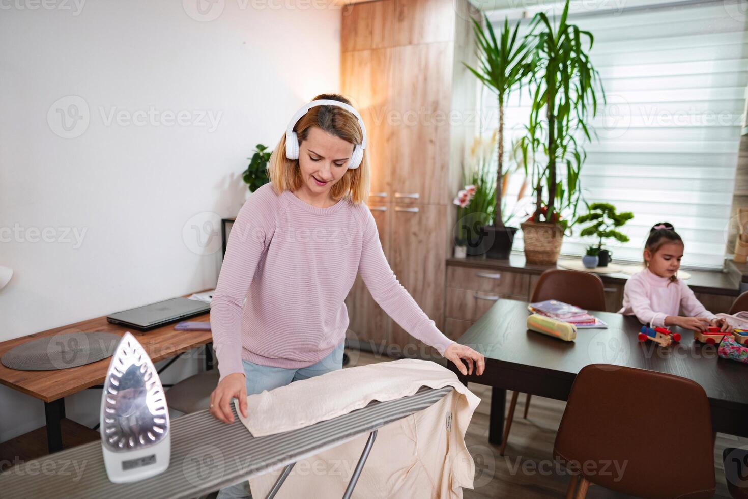 Enjoying a peaceful afternoon while ironing clothes at home with music photo