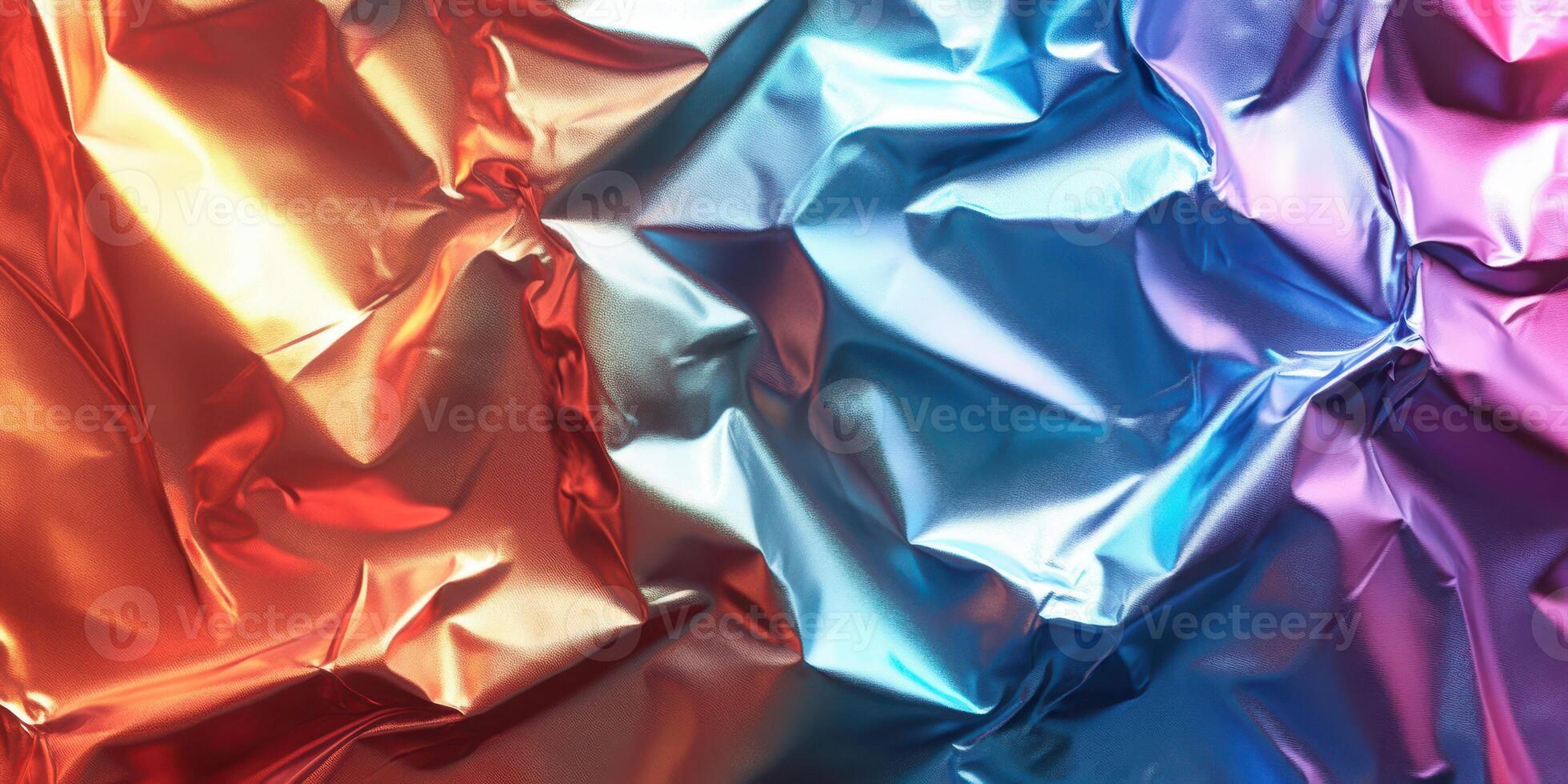 Colorful metallic foil creates an abstract texture with vibrant reflections in blue, red, and purple tones photo