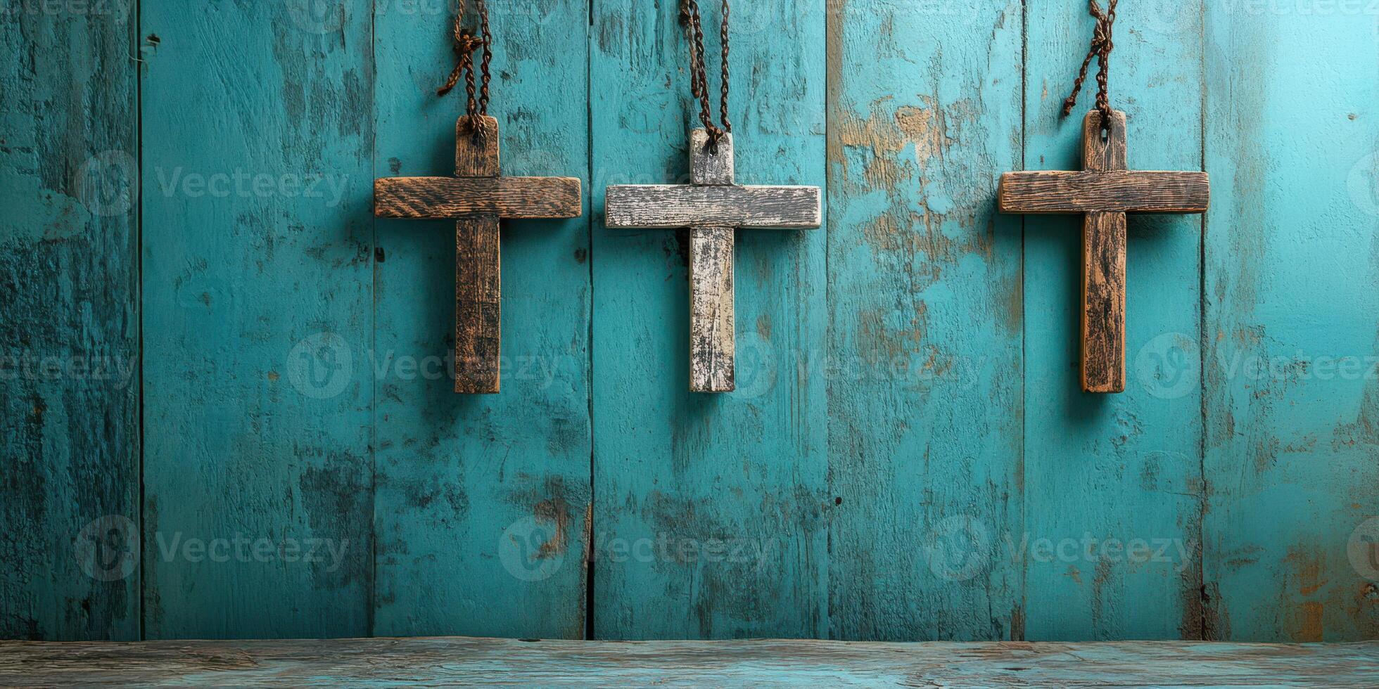 Three rustic wooden crosses hanging on a distressed turquoise background create a serene and spiritual atmosphere in the setting photo
