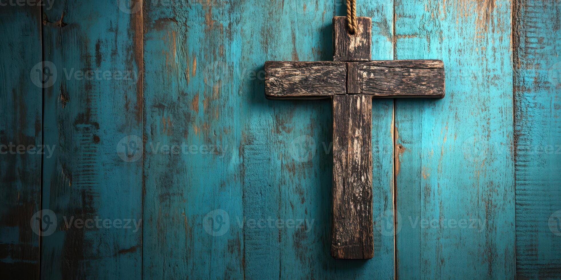 Rustic wooden cross against a vibrant teal wooden background in a serene setting photo