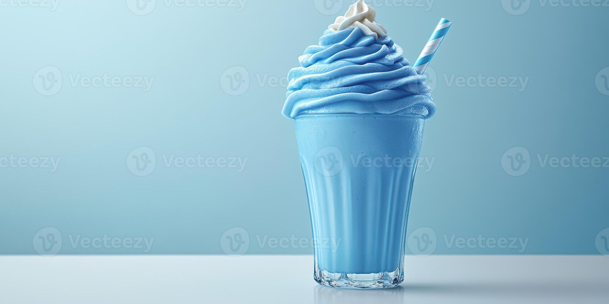 Delicious blue frozen dessert served in a clear glass on a light blue background with a striped straw photo