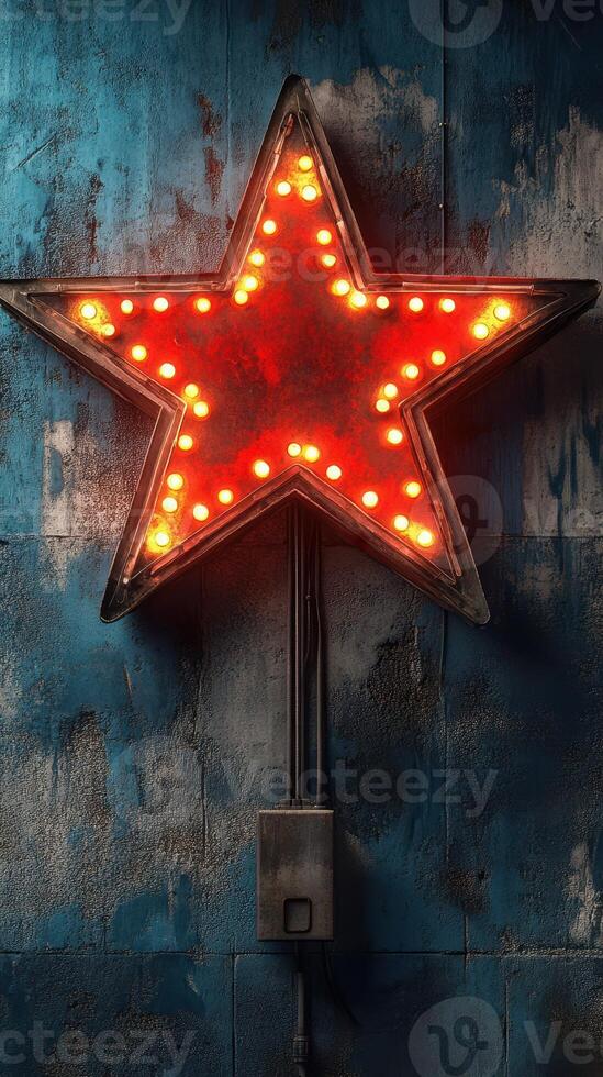 Bright red star marquee light illuminating a rustic blue wall in an urban setting at night photo
