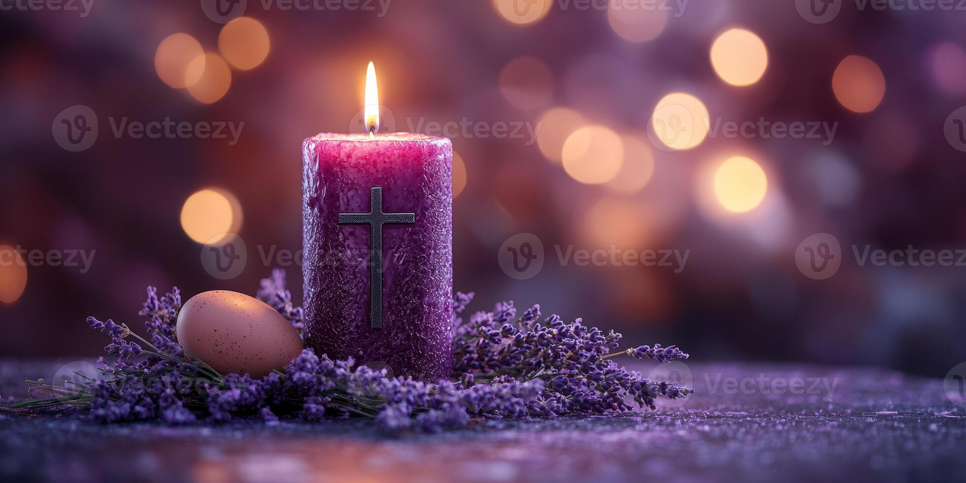 Purple candle with cross and egg surrounded by lavender on a softly lit table creating a serene atmosphere photo
