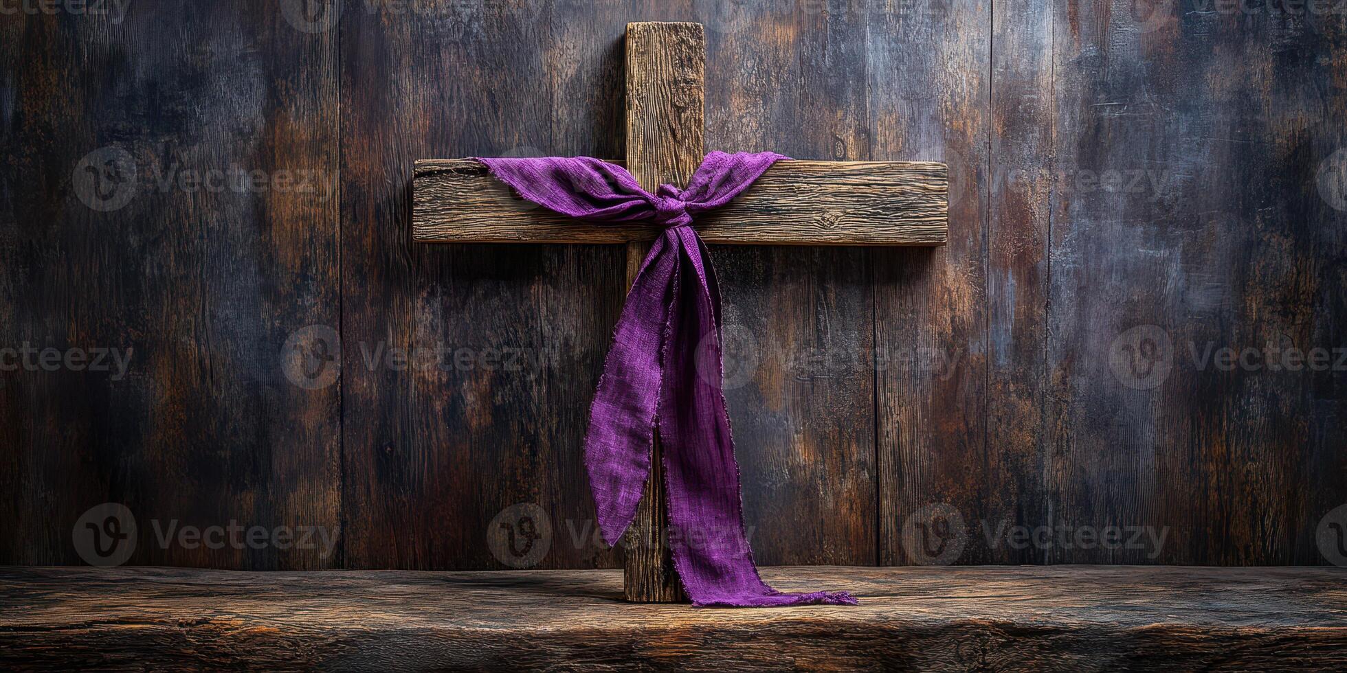 Wooden cross adorned with purple cloth on rustic wooden surface in a serene setting photo