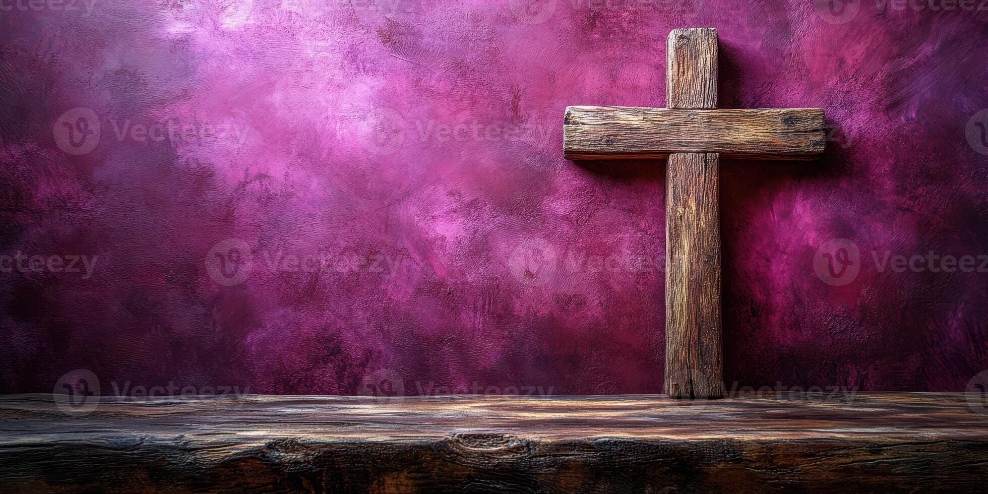 Wooden cross displayed against a textured purple background with rustic wooden table in soft lighting photo