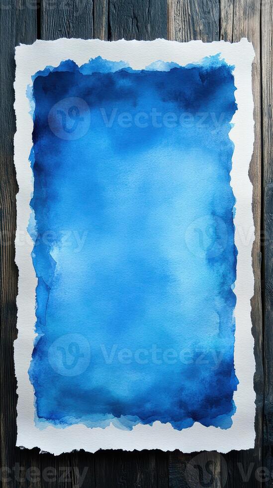 Blue watercolor art piece on textured paper background with wooden surface photo
