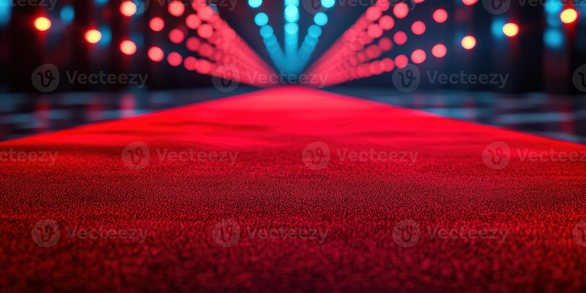 Red carpet leading to bright stage lights in a glamorous venue during an evening event photo