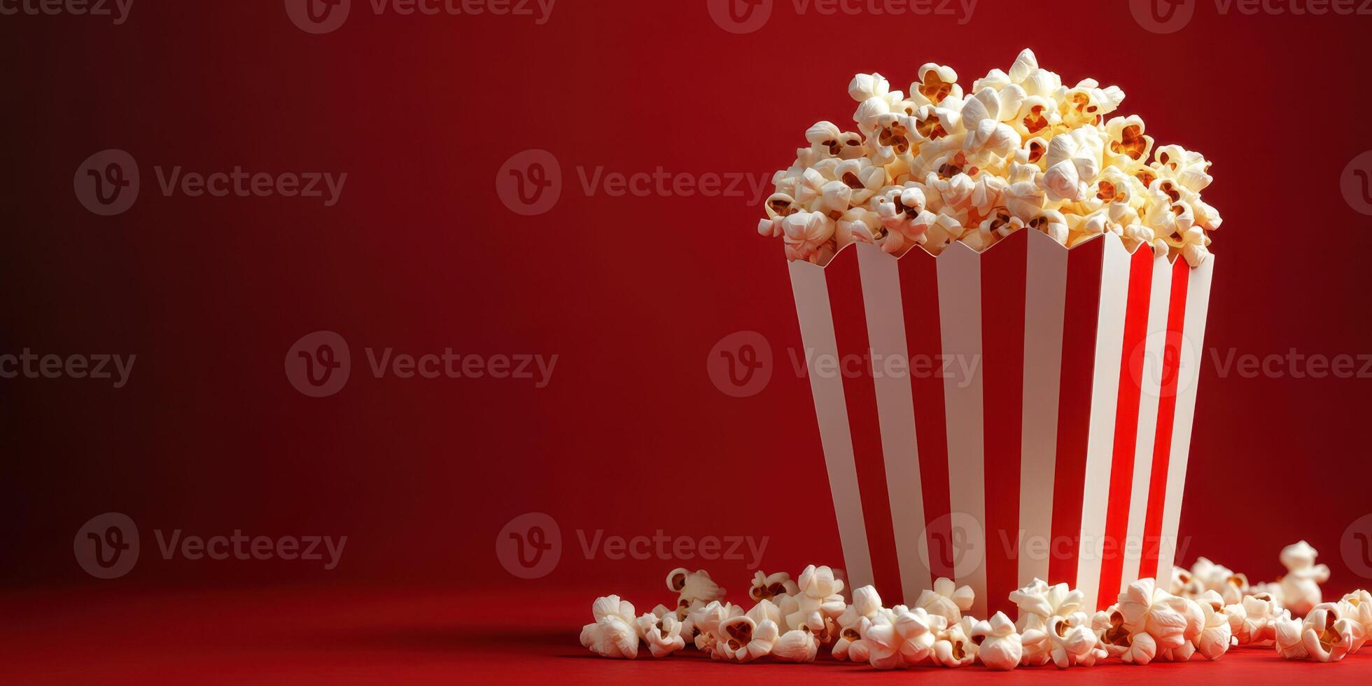 Popcorn in a striped container against a red background captures the essence of movie nights and snacks photo