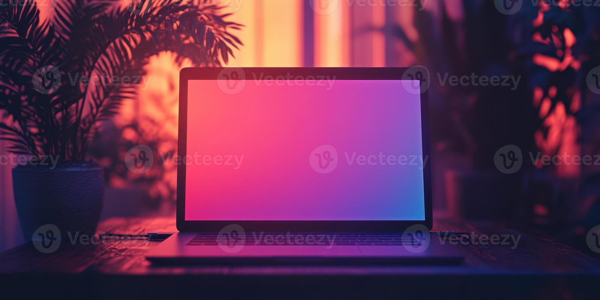 Laptop with colorful illuminated screen on a wooden table surrounded by plants in a cozy indoor setting photo
