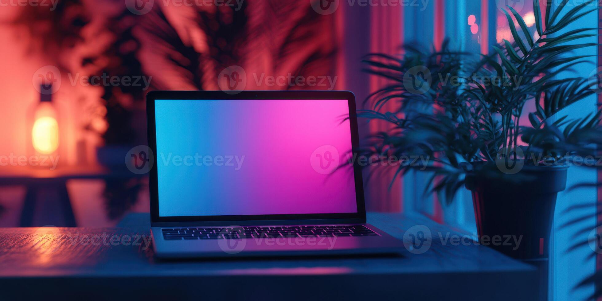 Elegant workspace at night featuring a laptop with soft colorful lighting and plants for a calming atmosphere photo