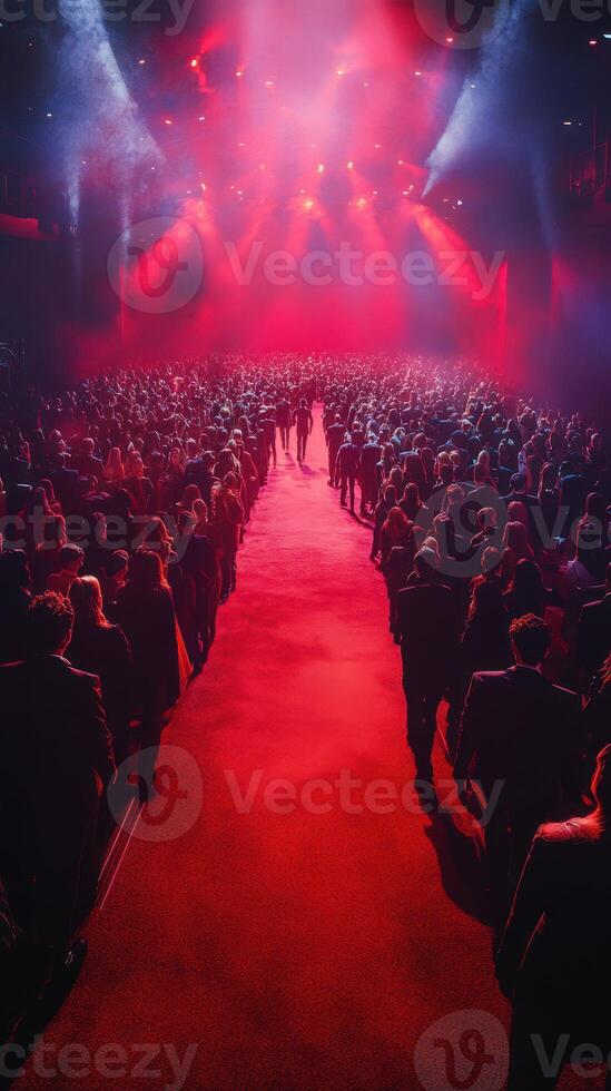 Large crowd gathers at a vibrant concert venue with red lighting during an electrifying performance photo