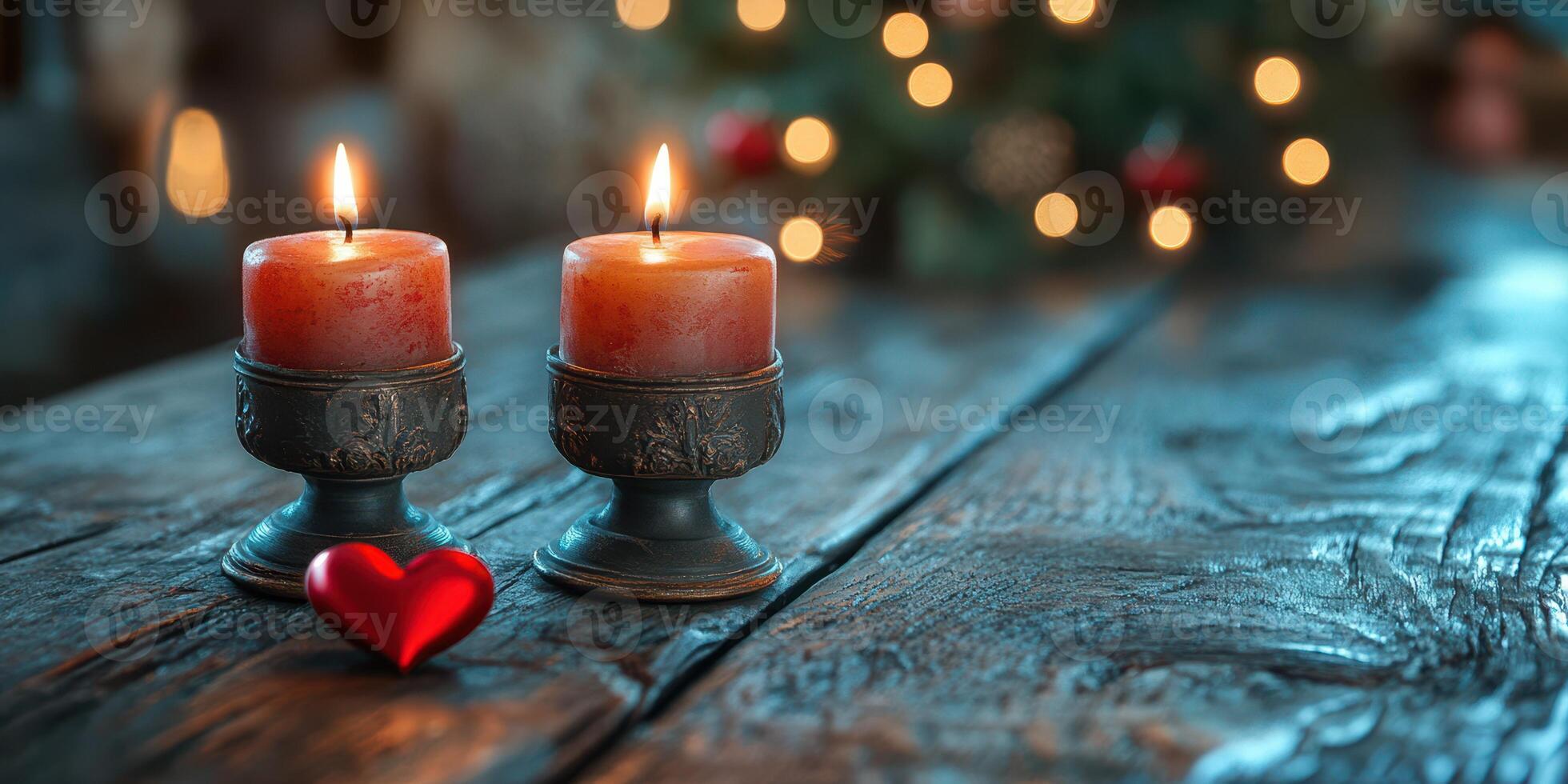 Two glowing candles on a rustic wooden table with a heart decoration and blurred Christmas lights in the background photo
