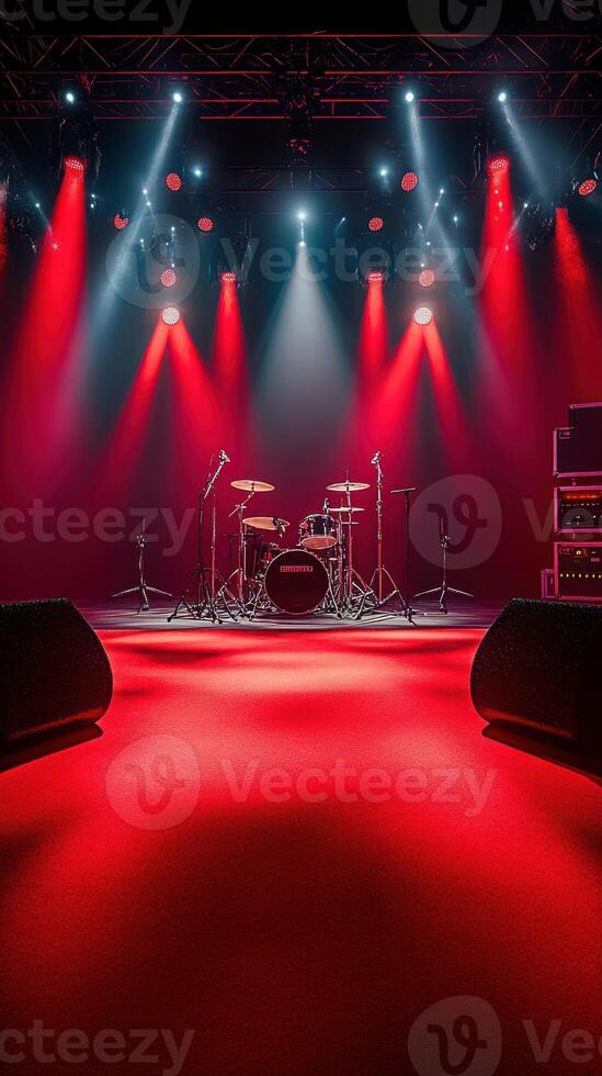 Dramatic red lighting highlights an empty stage with a drum set in preparation for a live music performance photo