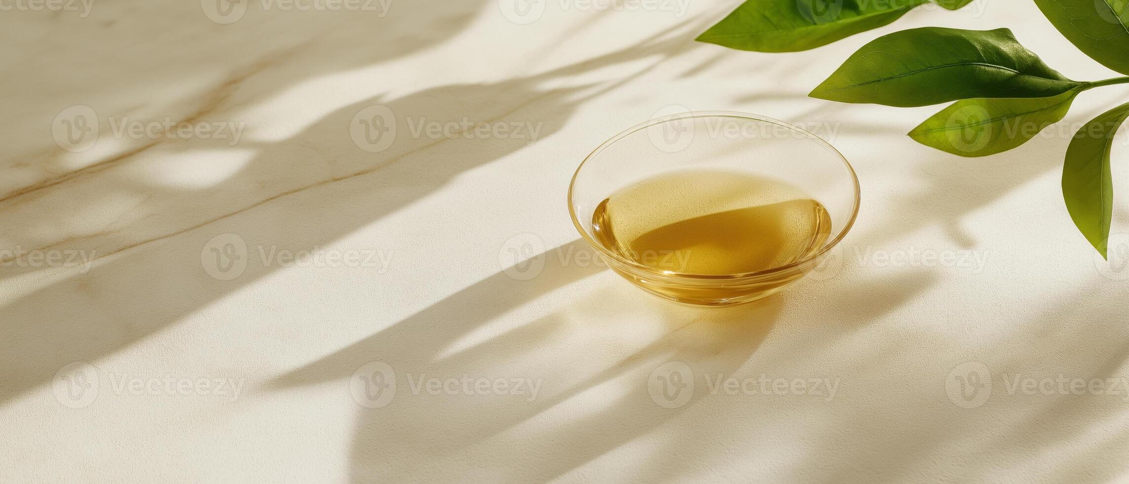 Golden Liquid in Glass Bowl, Leaves photo