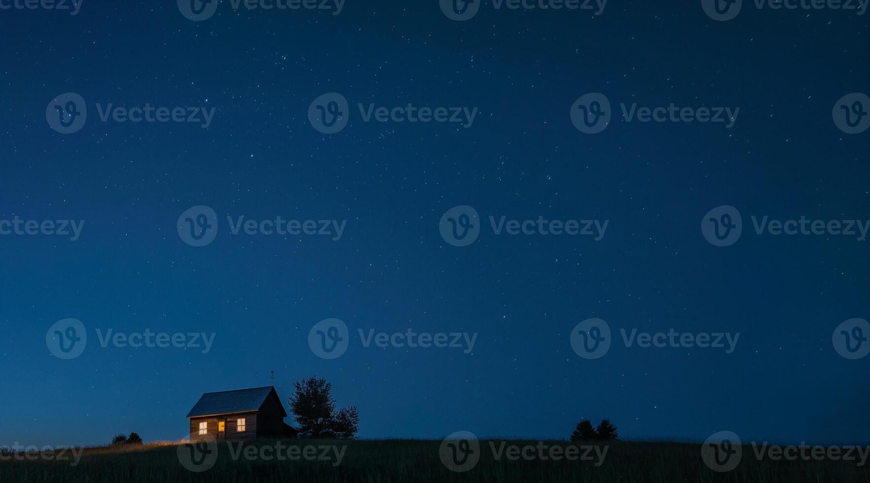 A small house sits on top of a hill at night photo