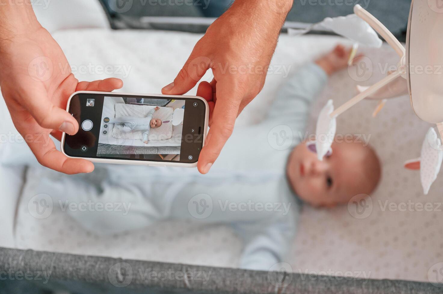 Taking ,picture by smartphone. Father with his newborn baby is indoors. Conception of single dad photo