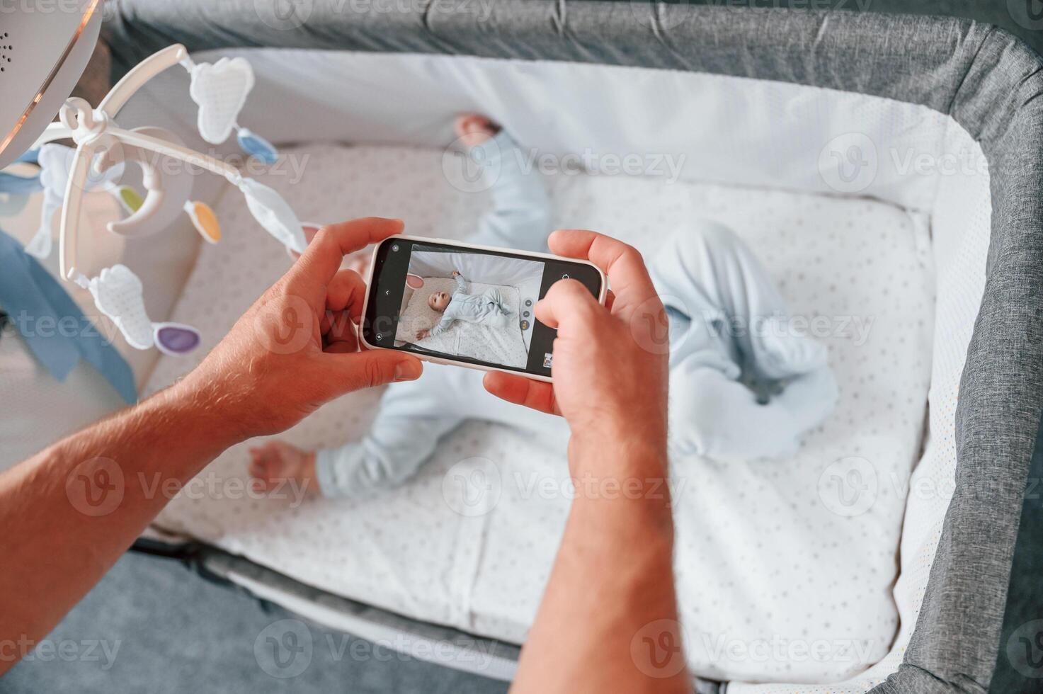 Taking picture by smartphone. Father with ,his newborn baby is indoors. Conception of single dad photo