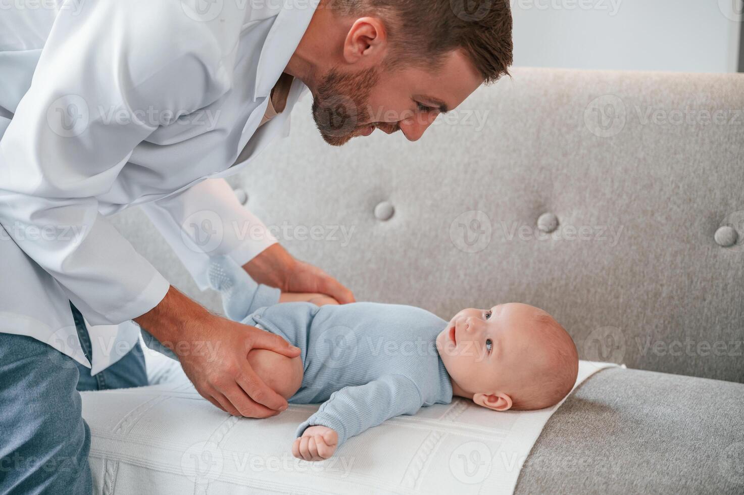 Professional ,doctor is taking care of newborn baby indoors in apartment photo