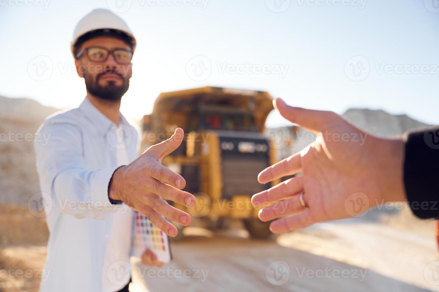 Giving a, hand. Making a deal. Man in uniform is working in the quarry at daytime photo