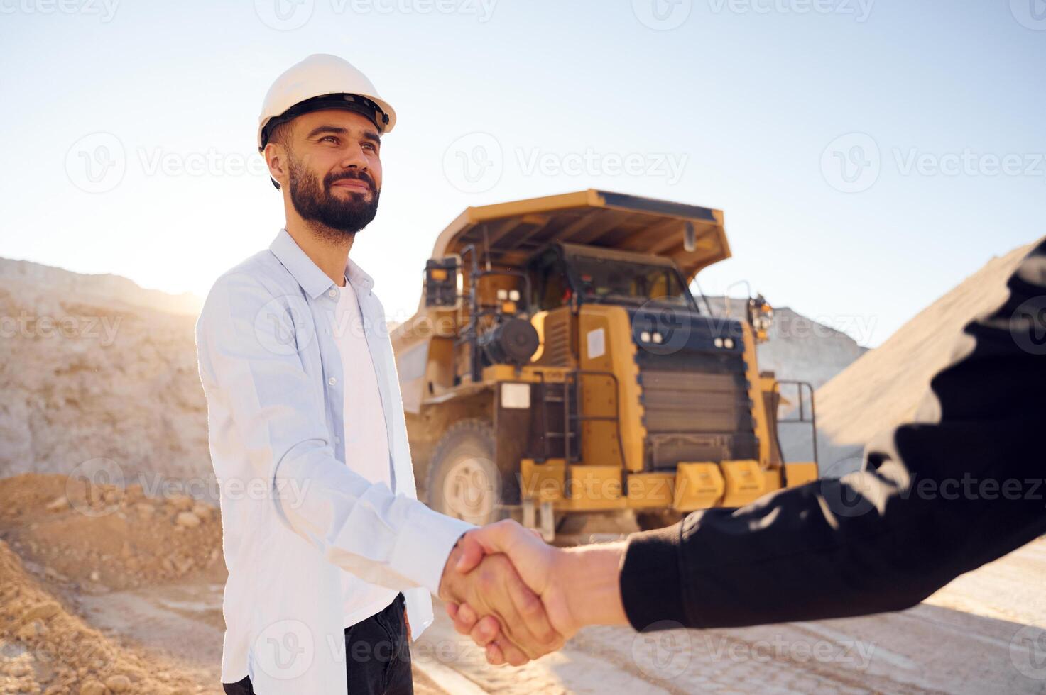Quarry worker making a deal with colleague. Shaking hands photo