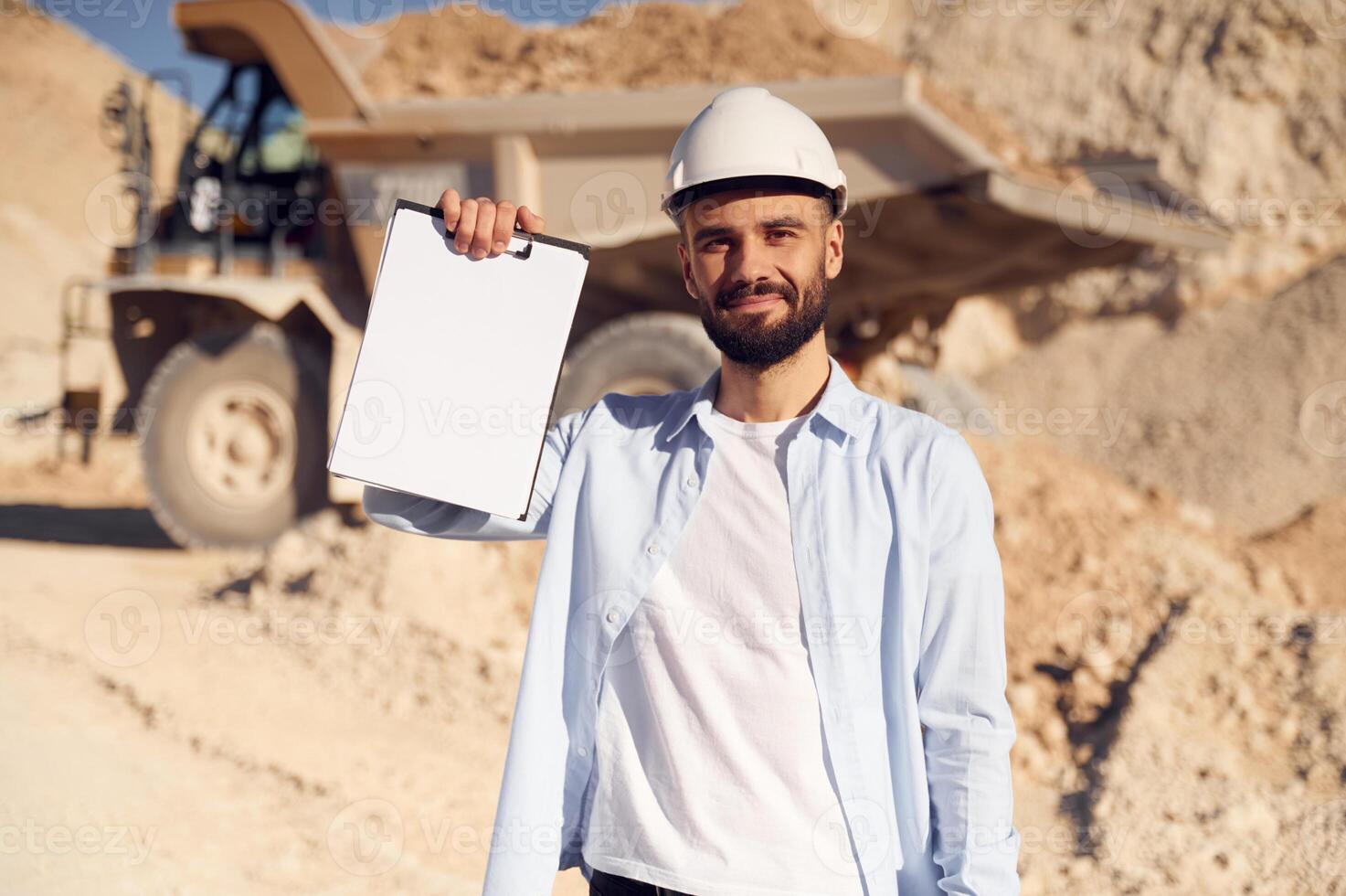 Document, to fulfill. Man in uniform is working in the quarry at daytime photo