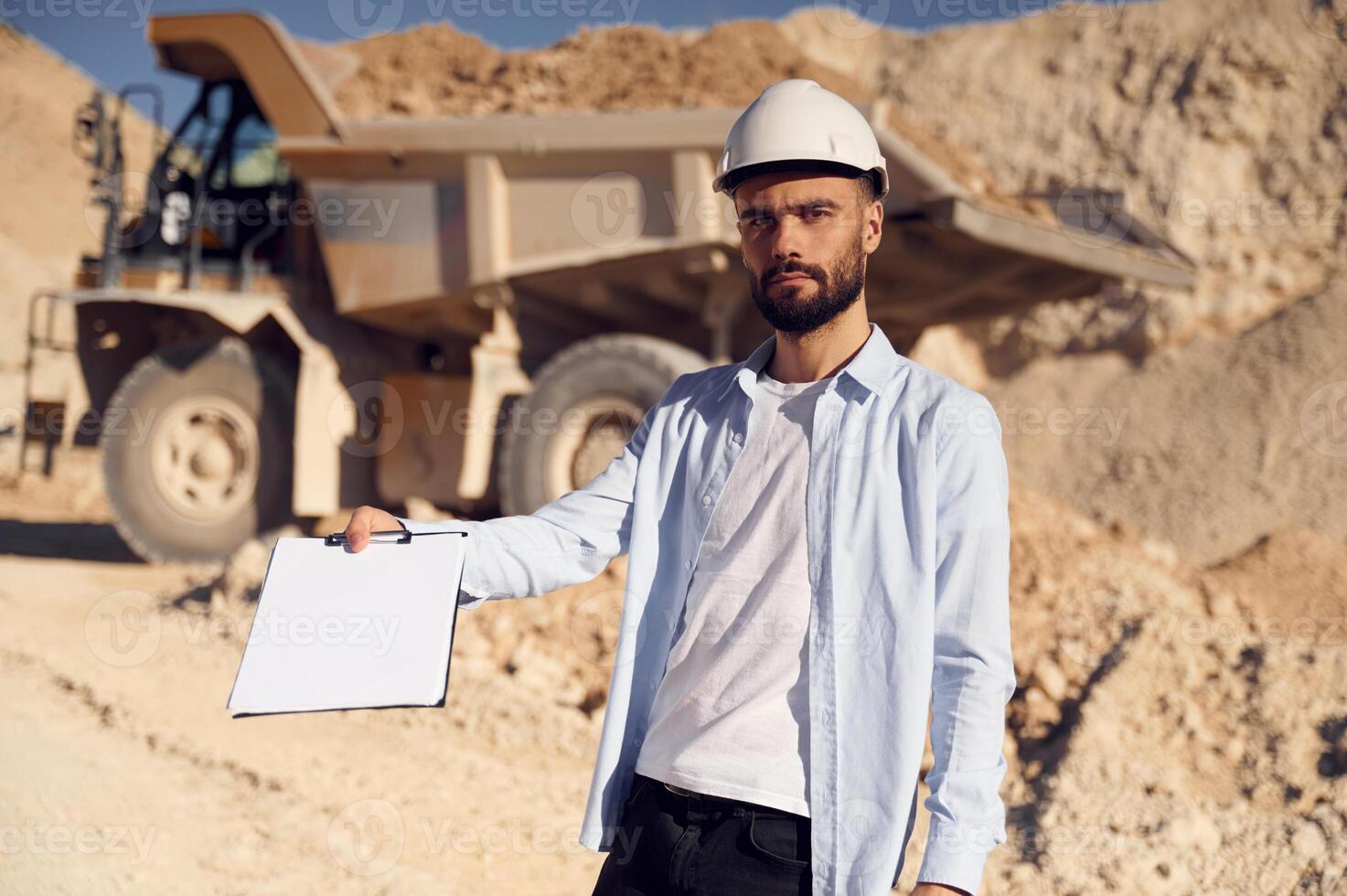 Document to fulfill. .Man in uniform is working in the quarry at daytime photo