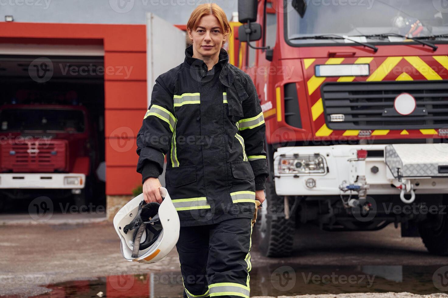 Walking forward. Woman firefighter in uniform is at work in department photo
