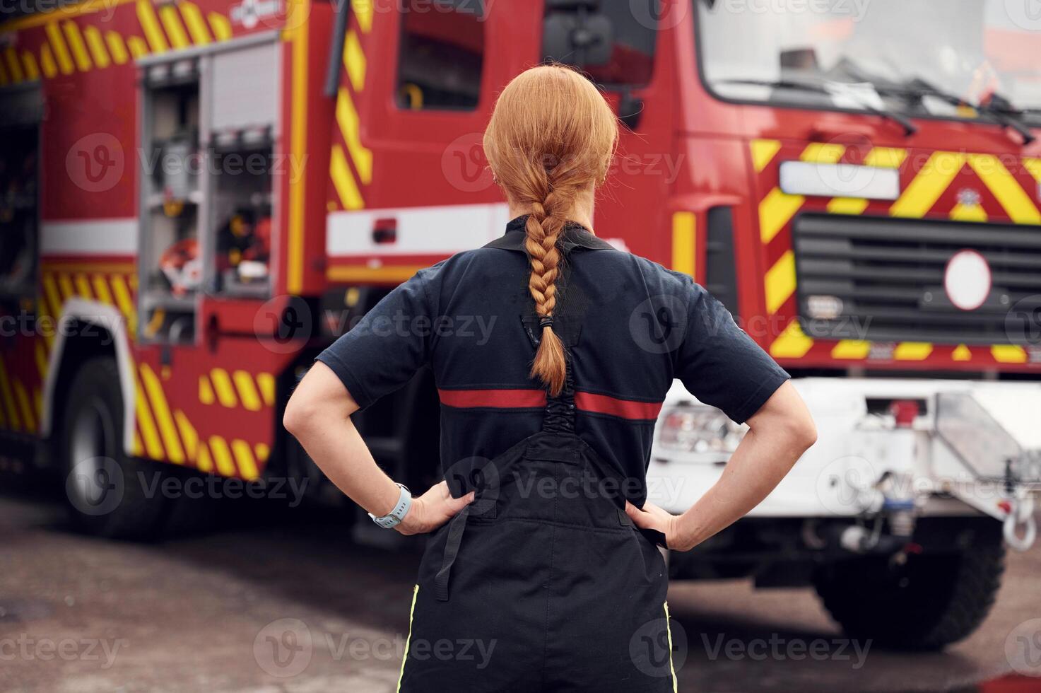 Rear view. Woman firefighter in uniform is at work in department photo