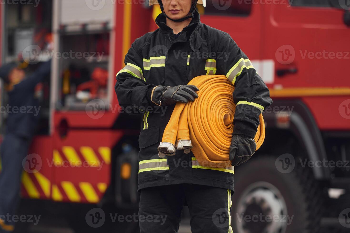 Holding fire hose. Woman in ,uniform is at work in department photo