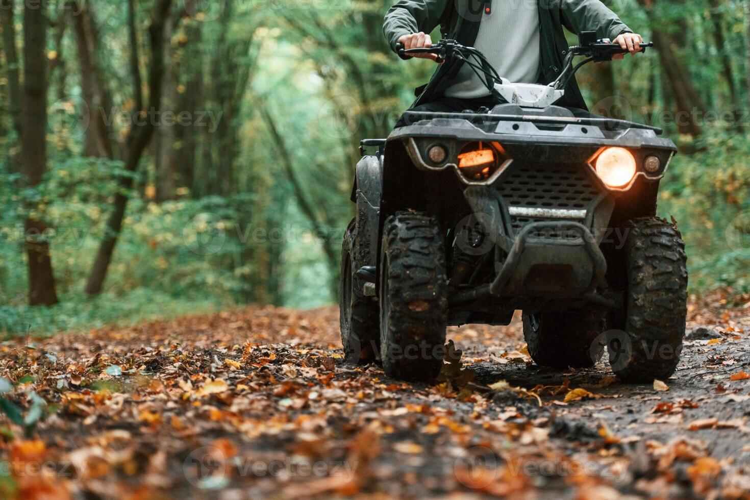 Close up view.. ATV driver is in the forest, having a ride at daytime photo
