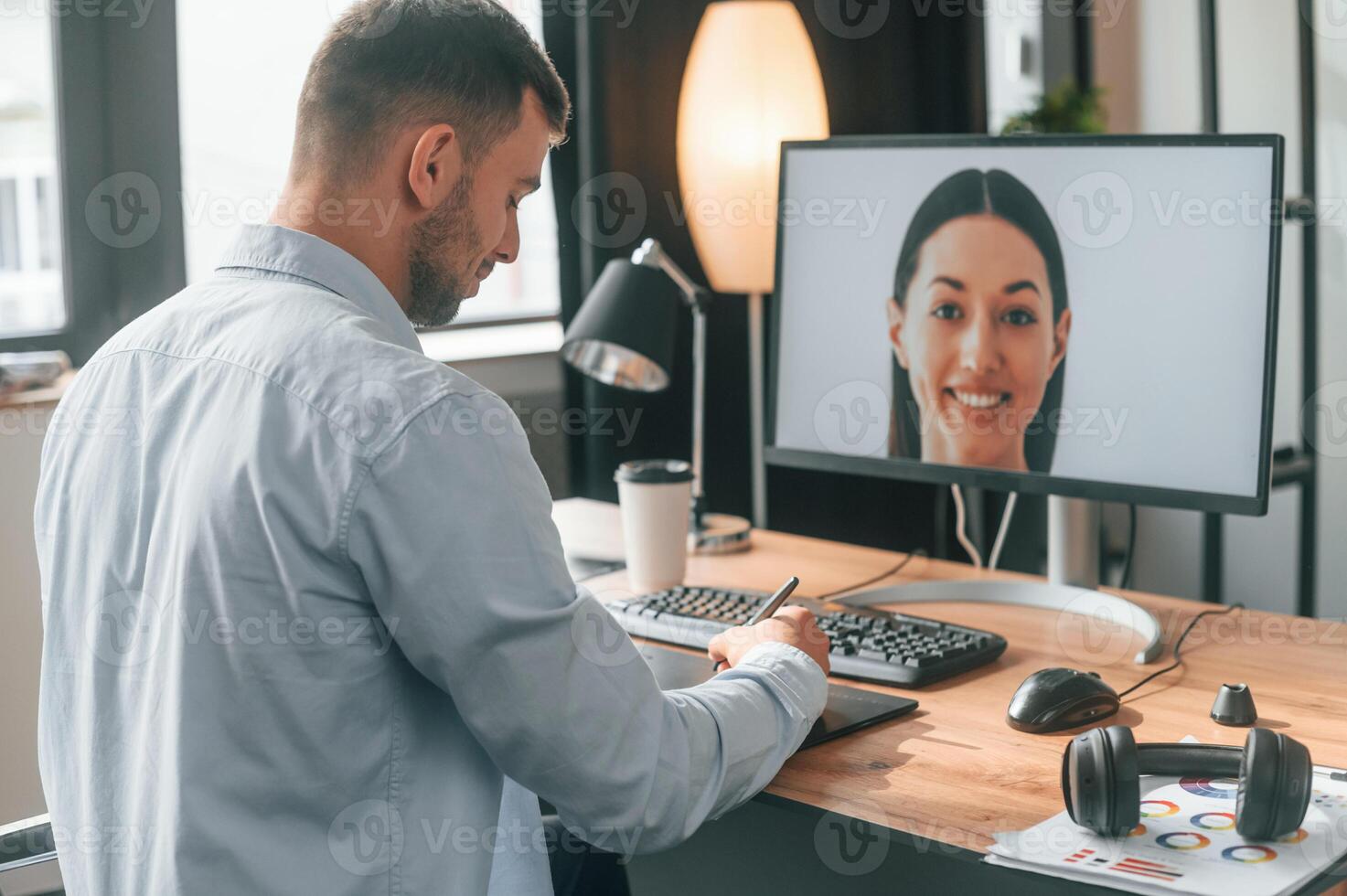 Retouching portrait of woman.. Designer is sitting by the computer and using graphics tablet with stylus photo