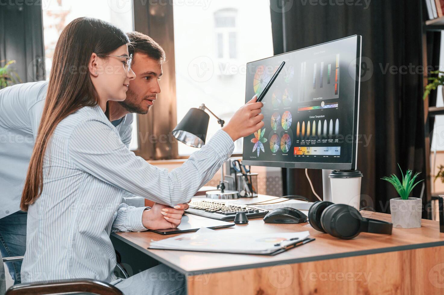 Using, computer. Two young designers is working together in the office photo