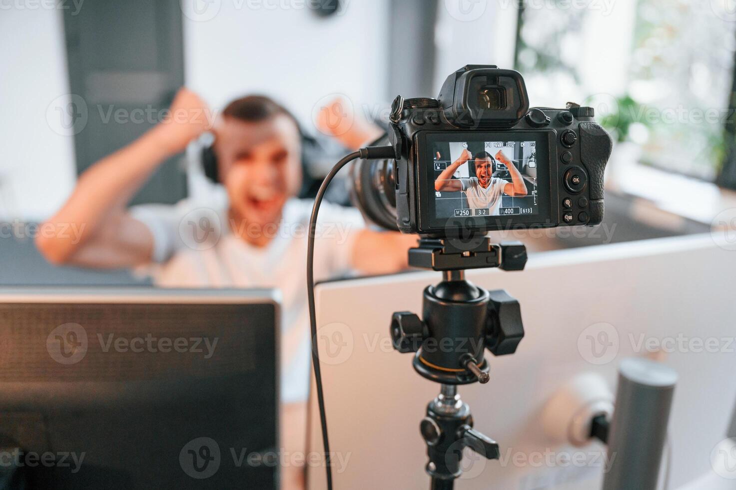 Process of recording. Young man playing and streaming the first person shooter game photo