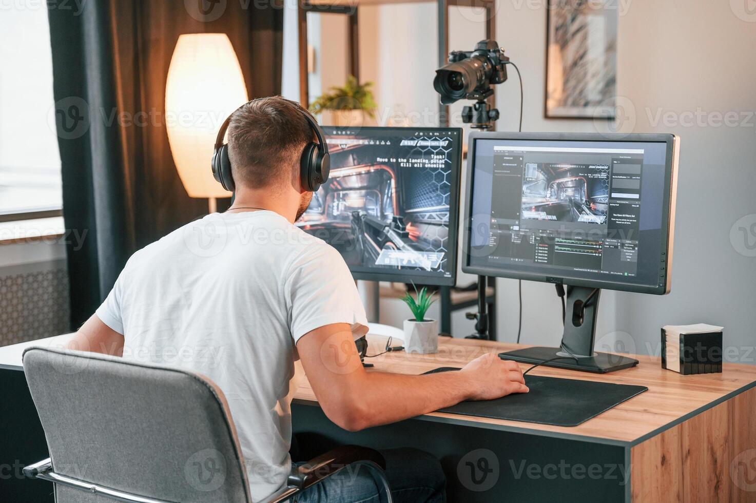 Sitting and ,focused. Young man playing and streaming the first person shooter game photo