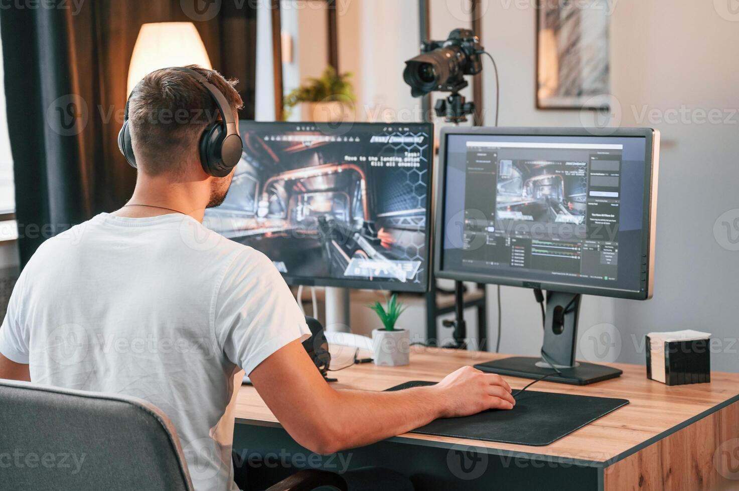 Sitting and focused. Young man playing, and streaming the first person shooter game photo