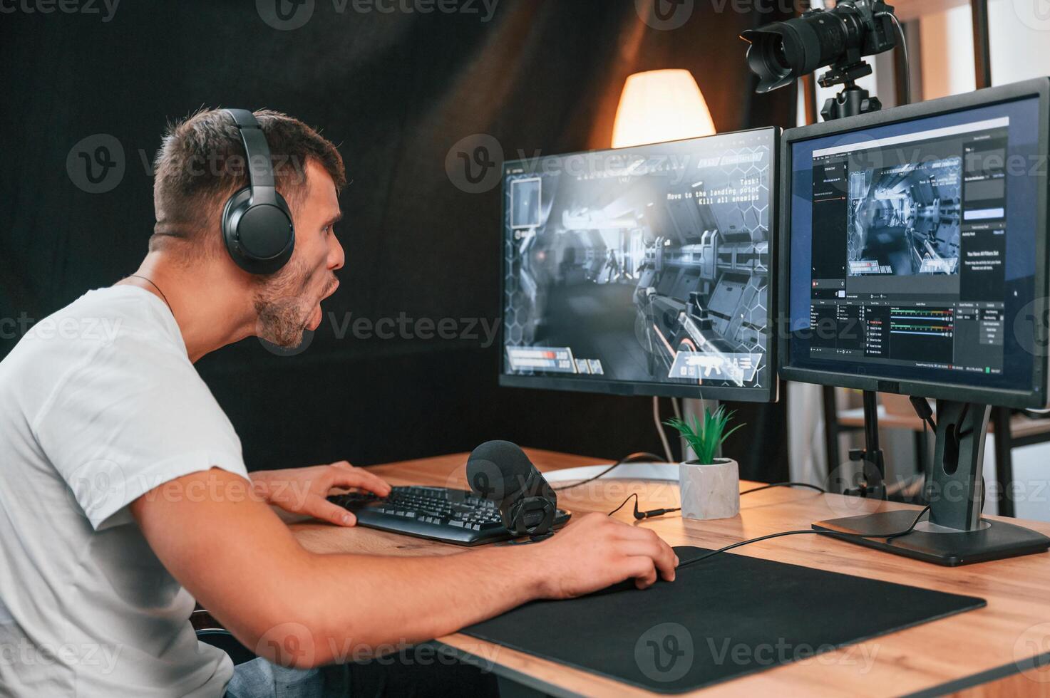 Young man playing and, streaming the first person shooter game photo