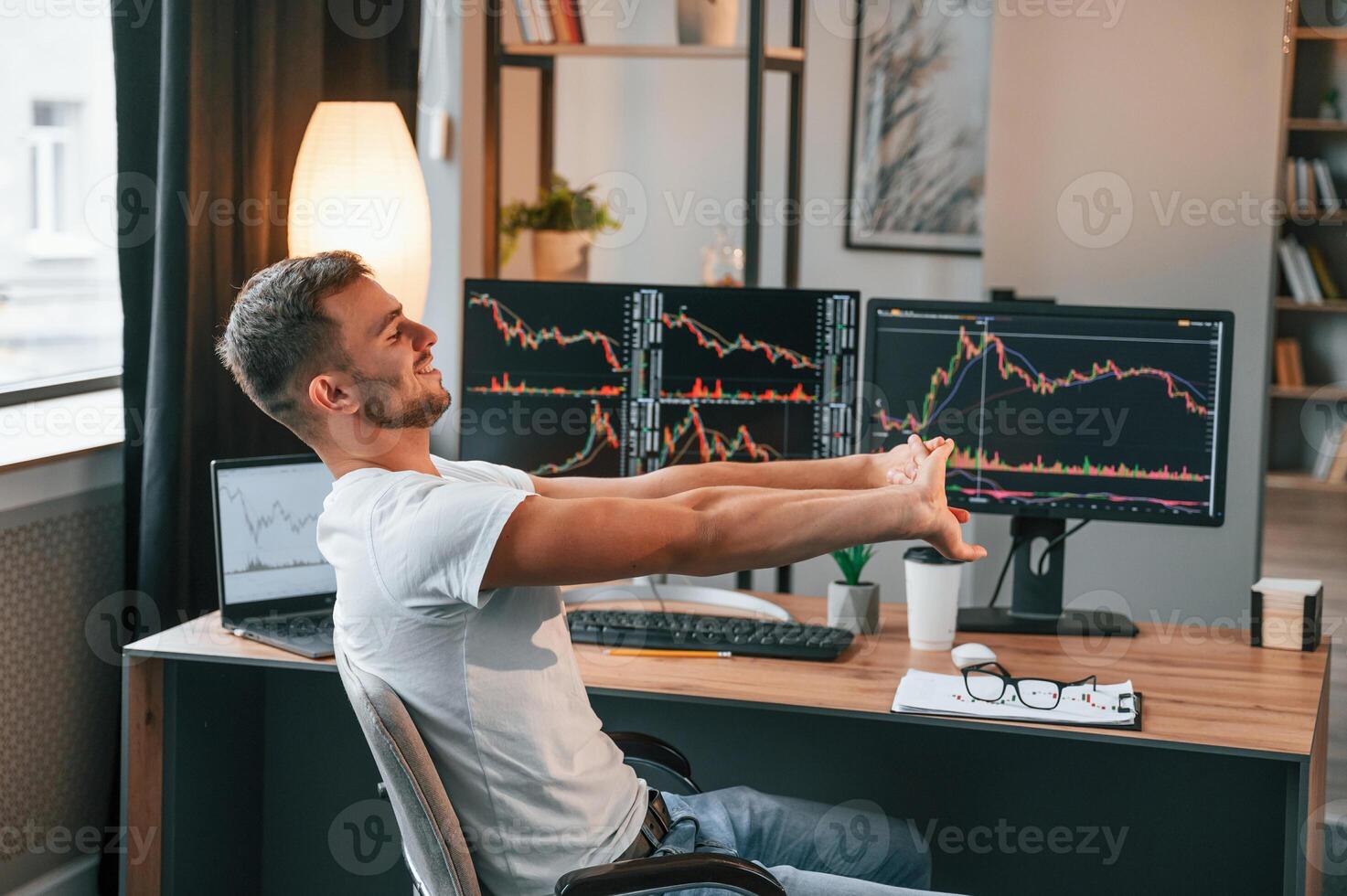 Taking a break. Young, stock broker ,is working in the office by using computer photo