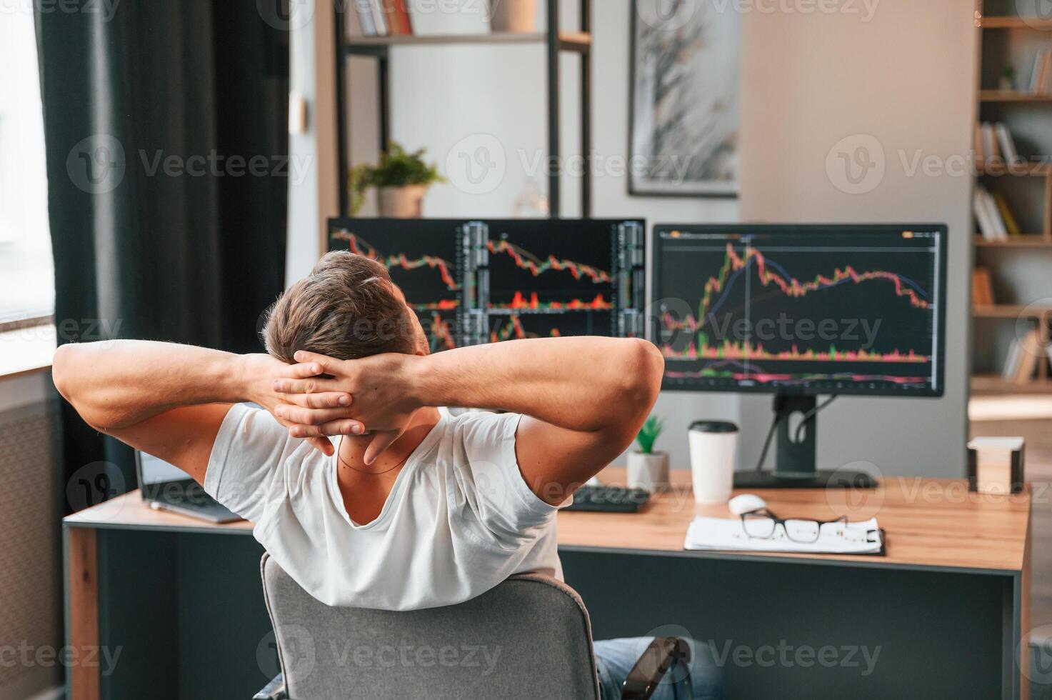 Taking a break. Young stock broker is working in the office by using computer photo