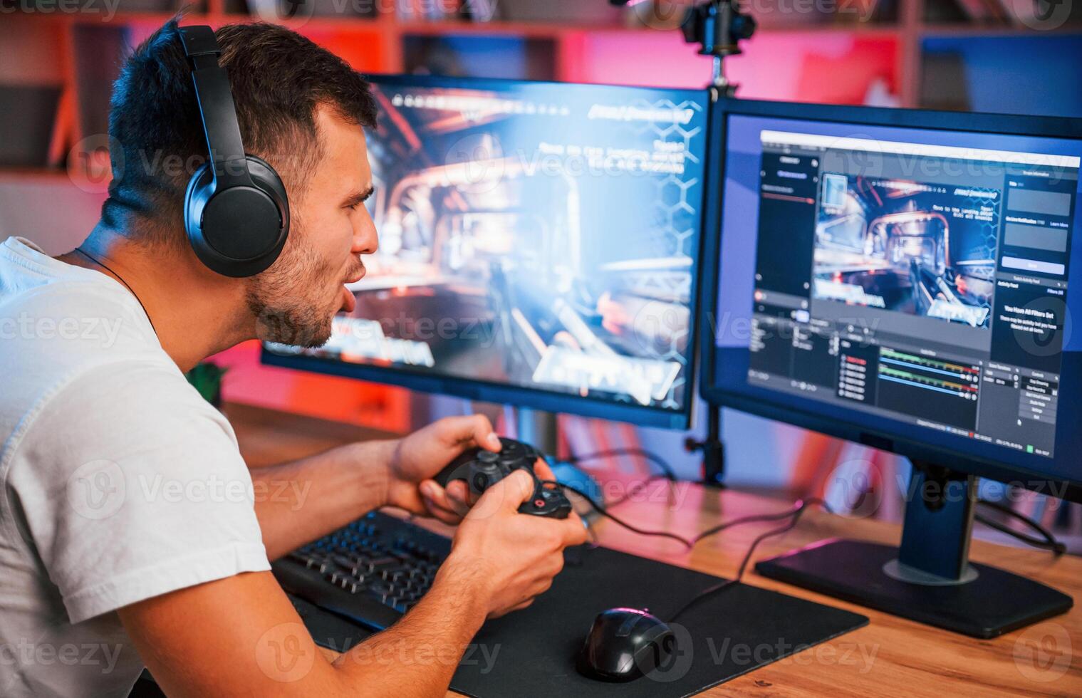 Male ,game streamer in casual clothes is i,ndoors with pc photo