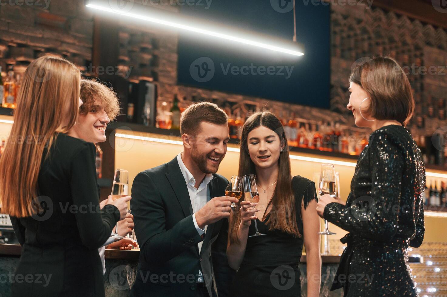 Group o,f people in elegant clothes are in the restaurant celebrating event photo