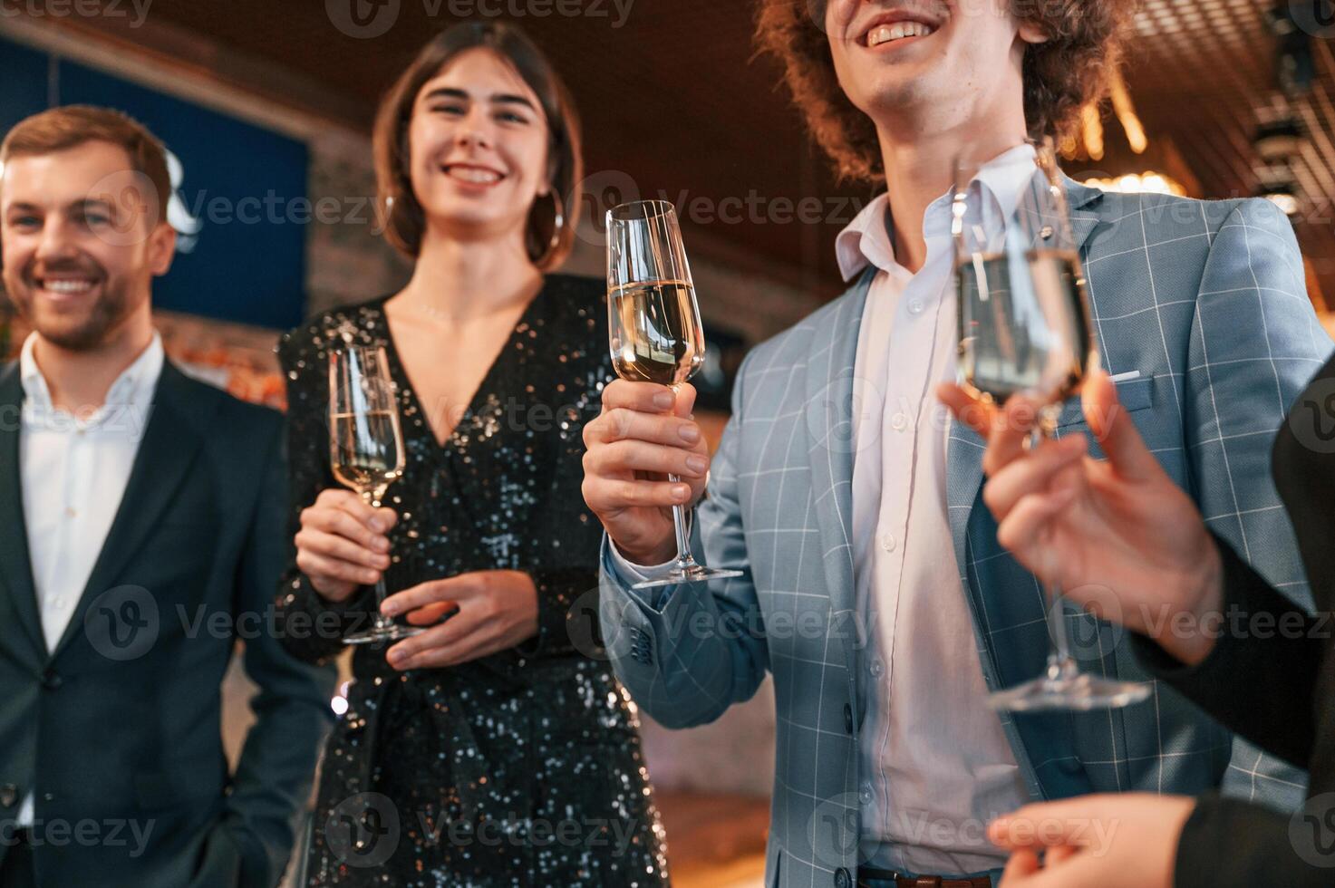 Talking ,and having fun. Group of people in beautiful elegant clothes are celebrating New Year indoors together photo
