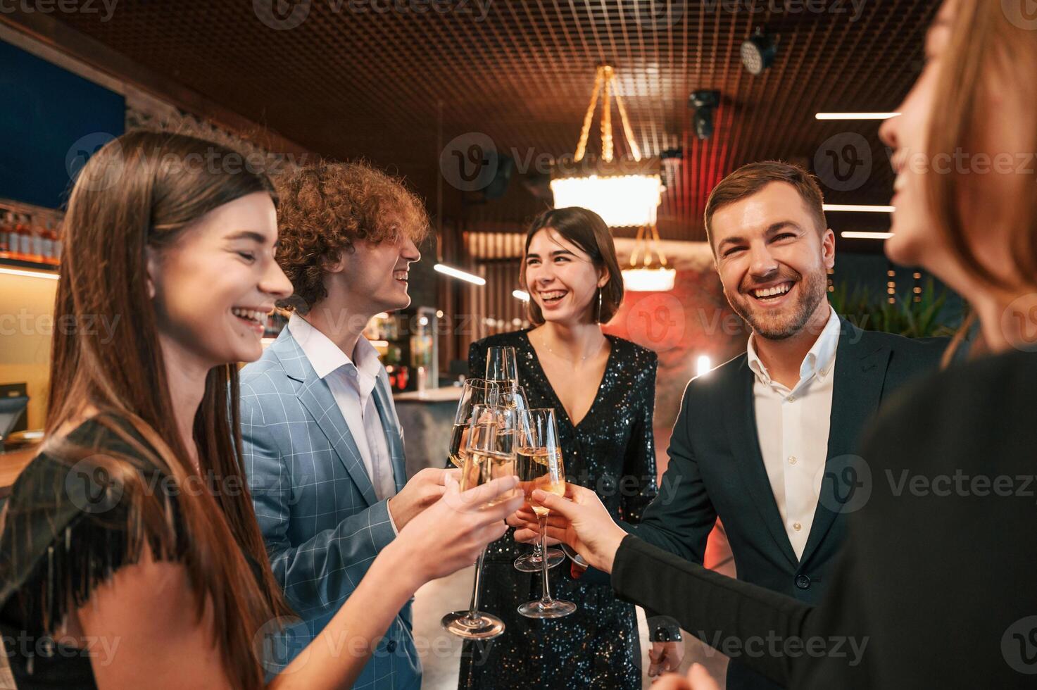 Talking and, having fun. Group of people in beautiful elegant clothes are celebrating New Year indoors together photo
