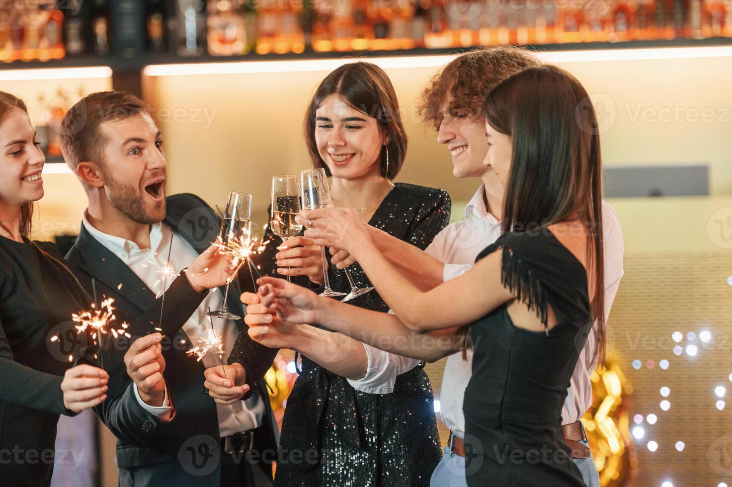 Having fun. Group ,of people ,in beautiful elegant clothes are celebrating New Year indoors together photo