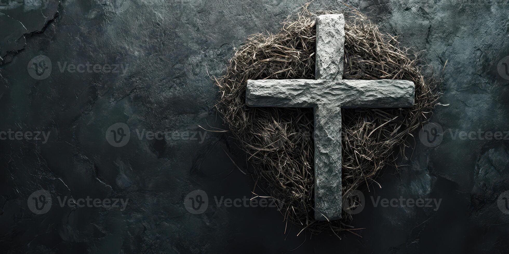 Cross made of stone rests on a dark surface surrounded by straw representing faith and spirituality in a somber setting photo