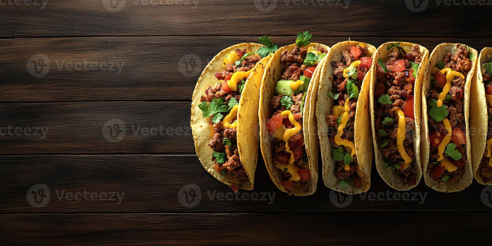 Tacos filled with meat, cheese, and fresh vegetables served on a wooden table at a casual dining setting photo