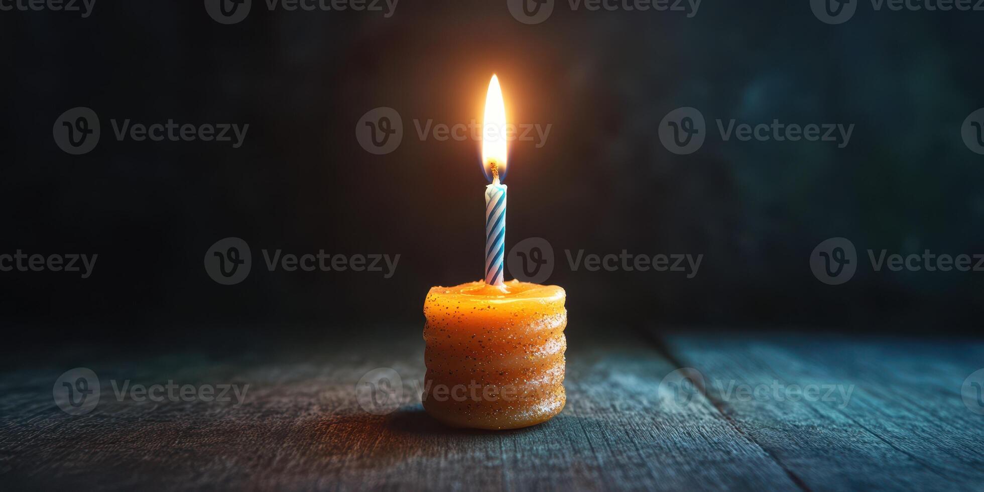 Candle glows softly in a dark room creating a warm intimate atmosphere during a quiet evening photo