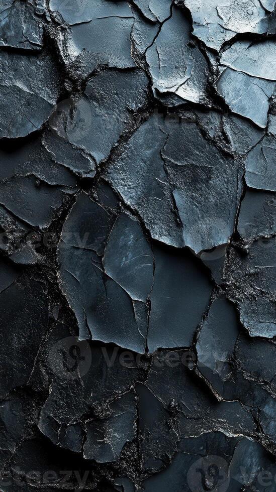 Unique textured surface formed by cracked dark rock layers in a natural environment photo