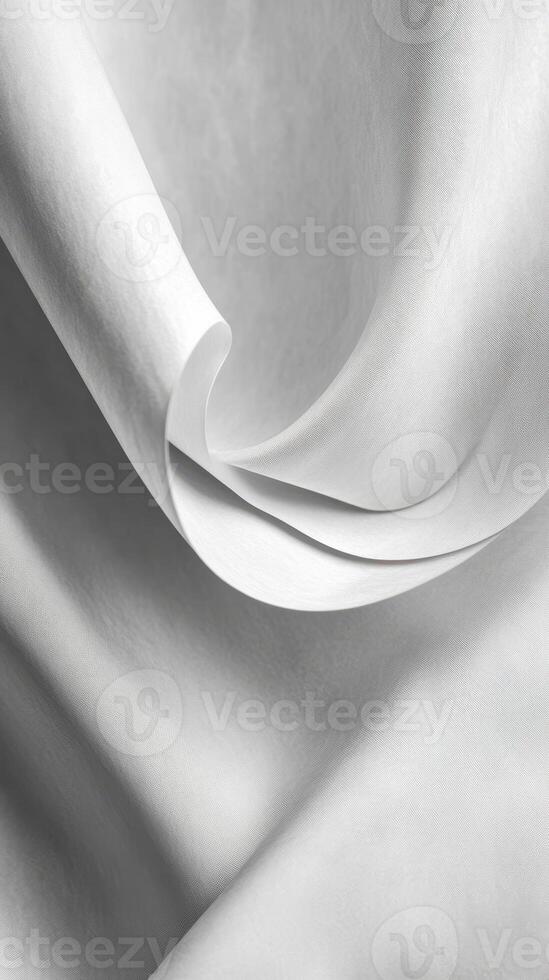 Delicate folds of soft white fabric drape gracefully in the light showcasing texture and movement photo