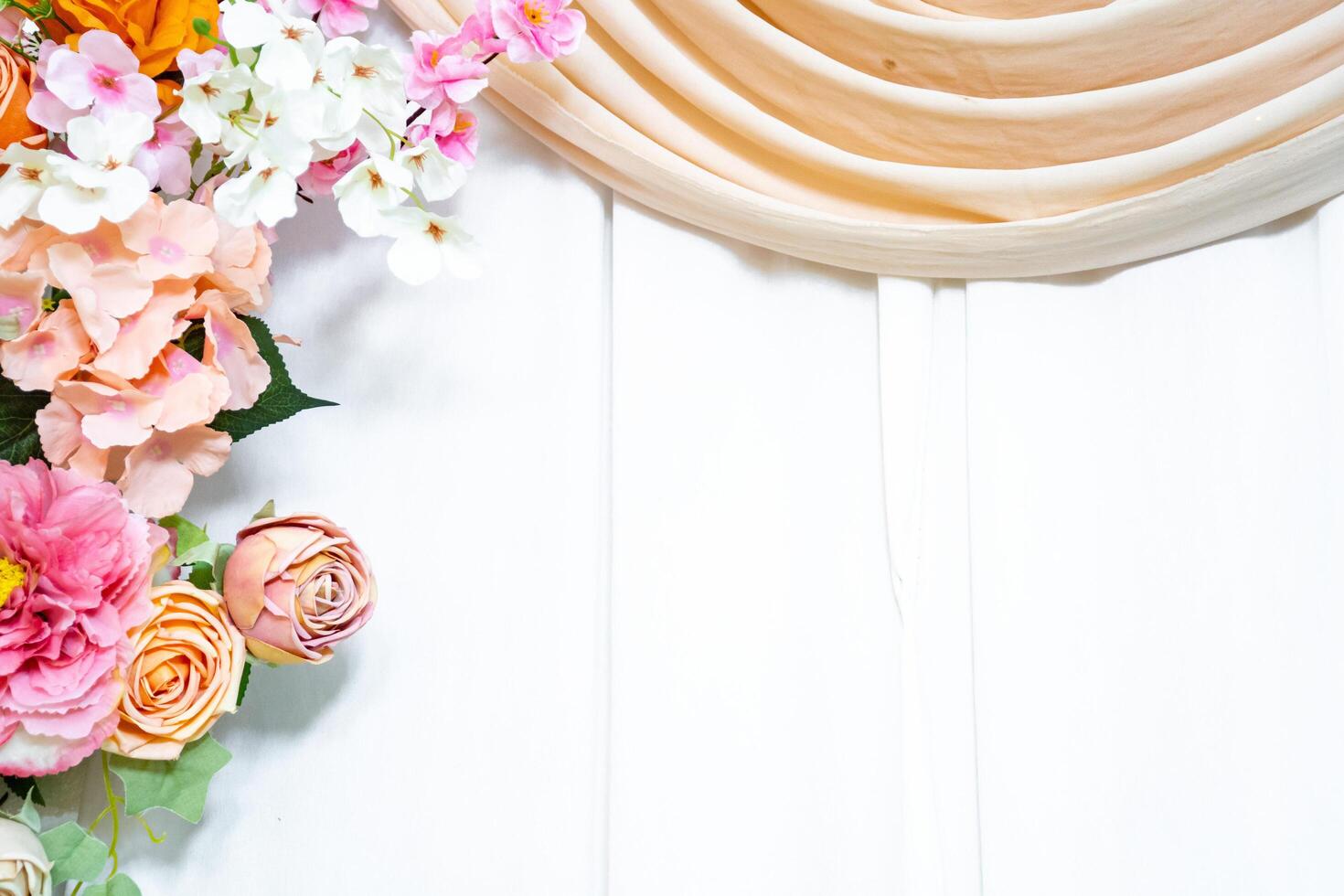 Elegant flower arrangement on white wooden background with fabric drape romantic wedding backdrop. photo